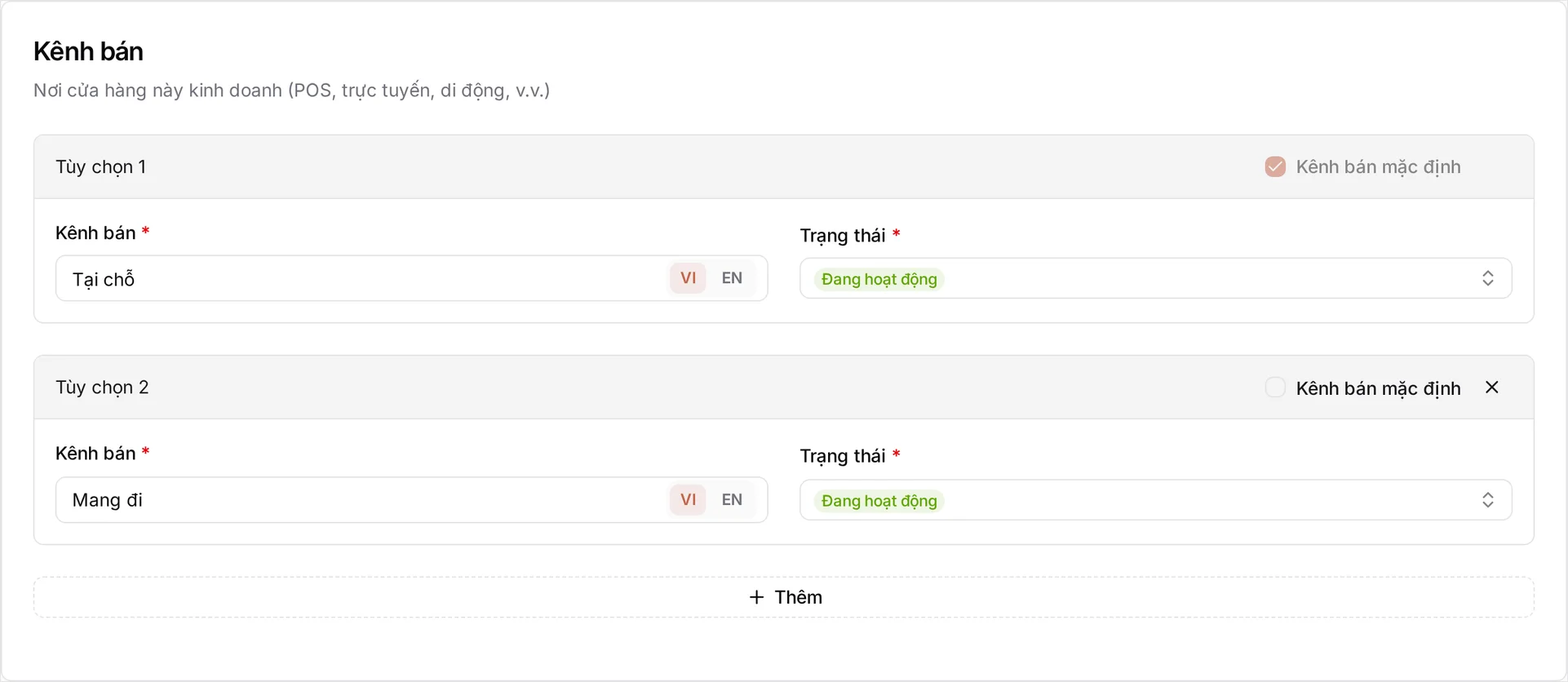 Thẻ Kênh bán — 'Nơi cửa hàng này bán hàng (POS, online, mobile, v.v.)' — gồm Lựa chọn 1 là Tại chỗ được tích làm Kênh bán mặc định, và Lựa chọn 2 là Mang đi kèm dấu × để xóa; cả hai đều Đang hoạt động, mỗi ô tên có nút chuyển VI/EN, bên dưới là hàng + Thêm